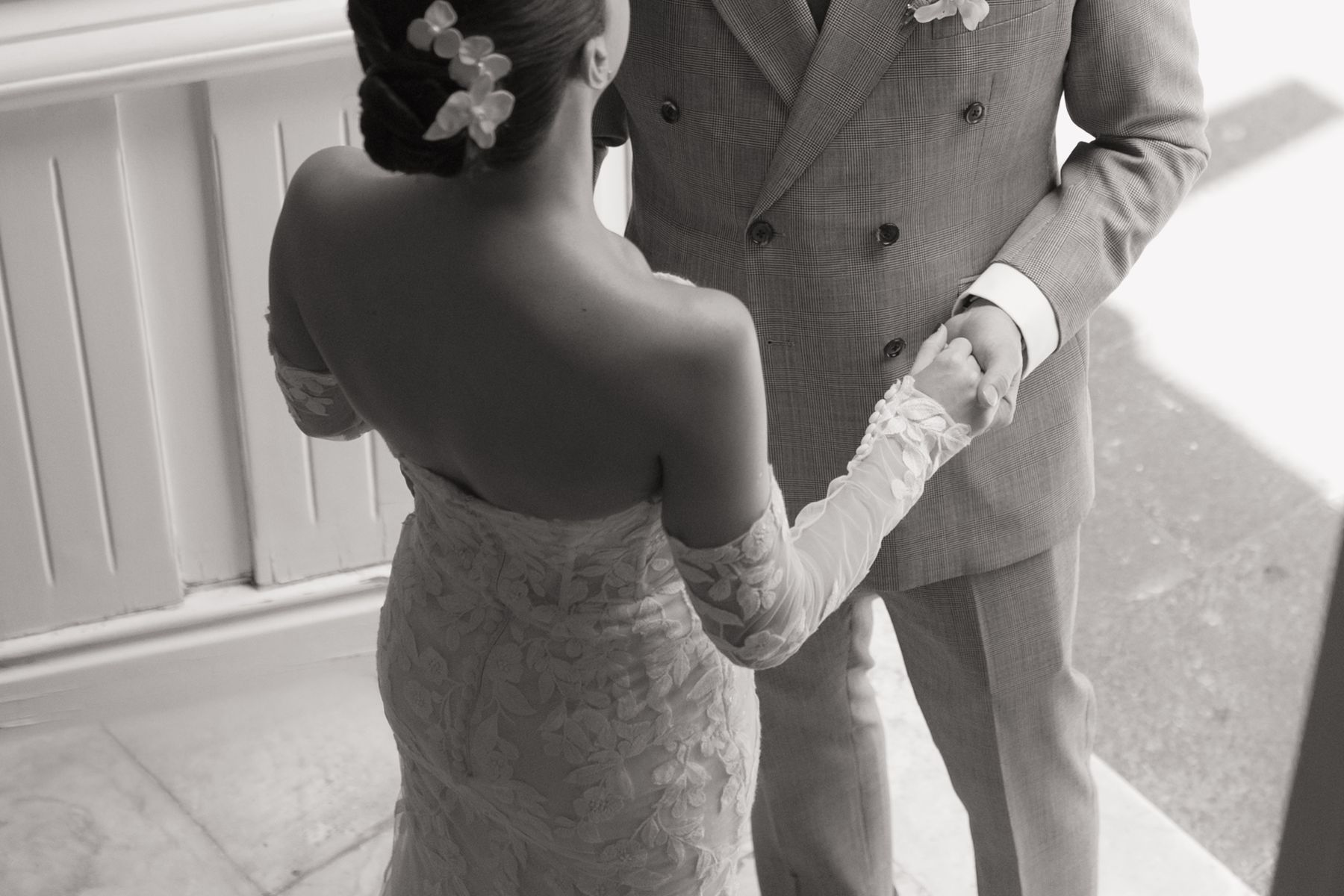 Bride seen from behind holding the groom's hand