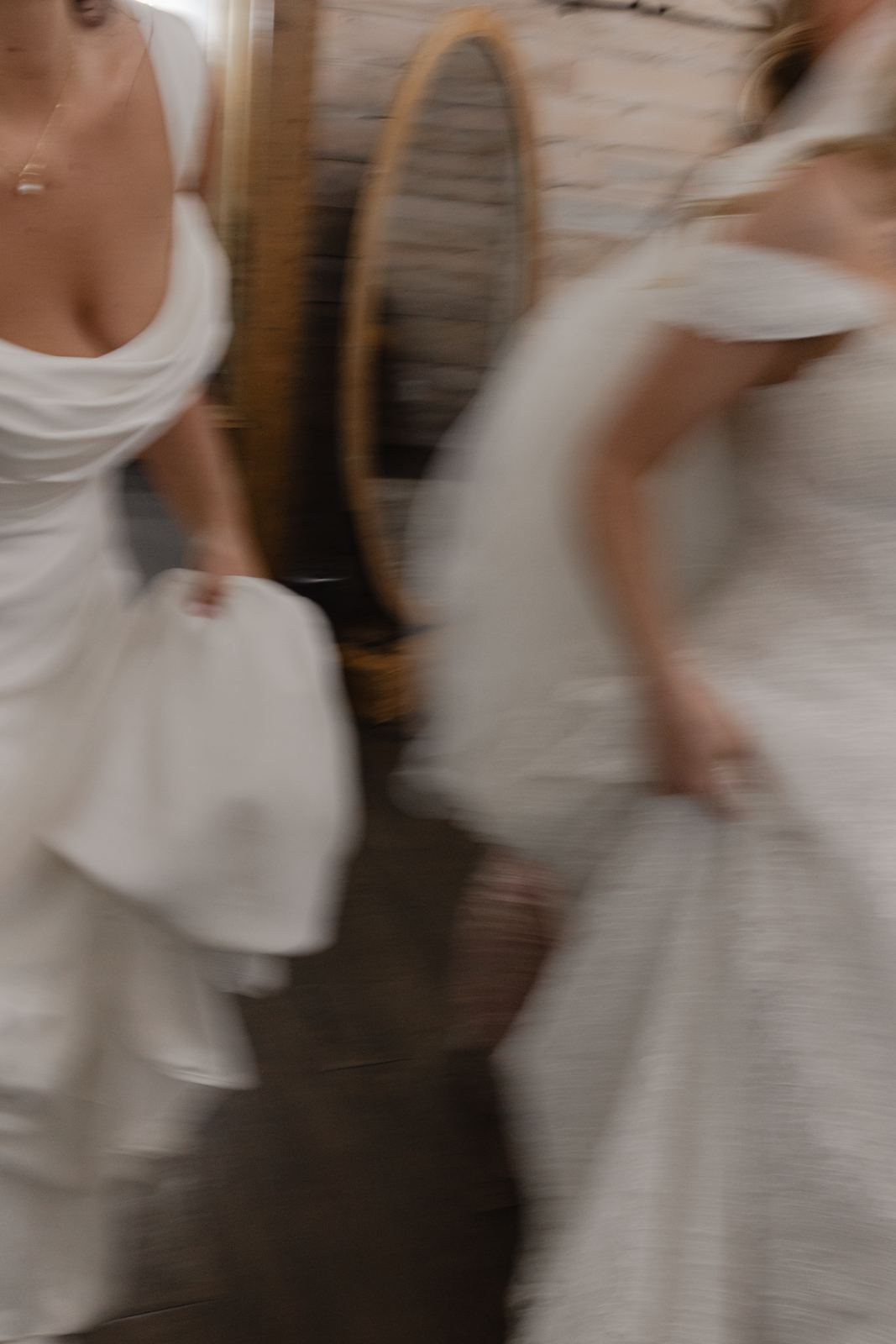 Two women in white gowns rushing past in motion blur