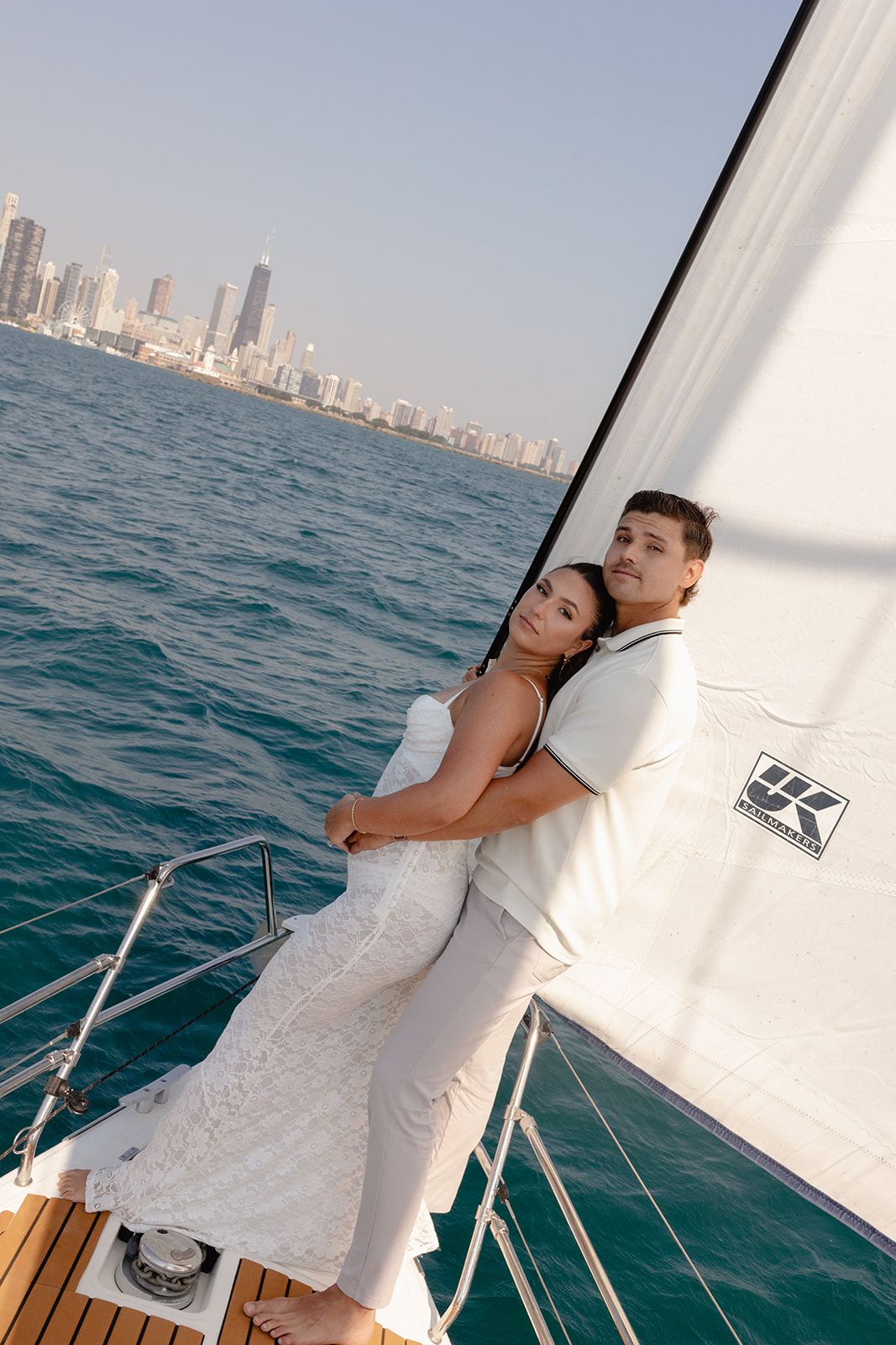 Couple embracing on a sailboat with the Chicago skyline across Lake Michigan