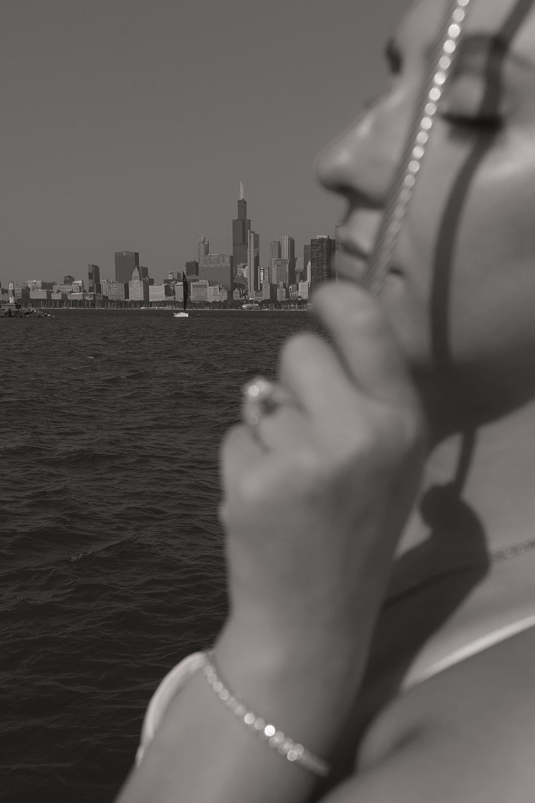 Woman's profile and engagement ring against the Chicago skyline, black and white