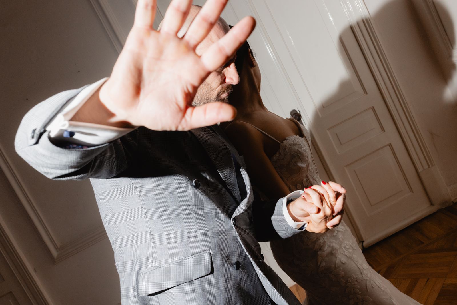 Groom playfully blocking the camera while dancing with the bride
