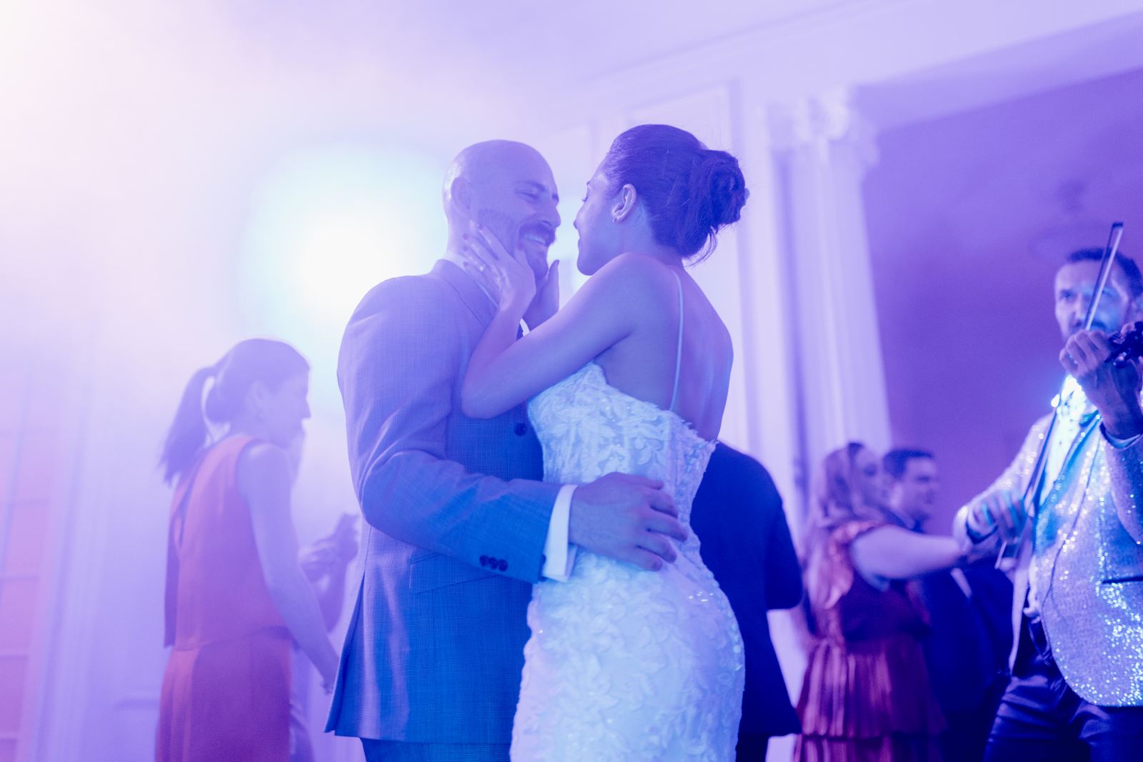 First dance under purple lights with a violinist playing nearby