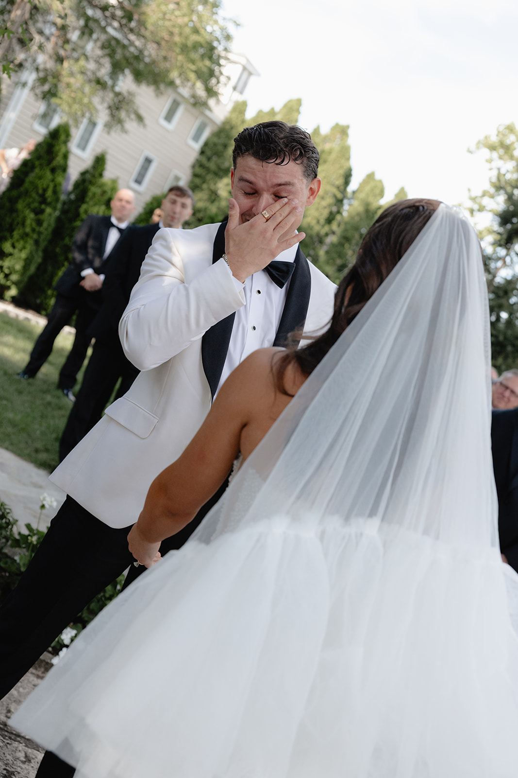 Groom wiping a tear as he sees the bride for the first time