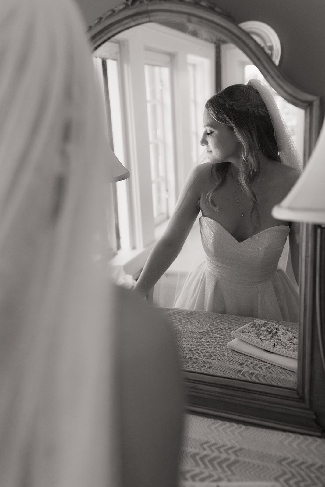 Bride in a strapless gown reflected in a vintage vanity mirror